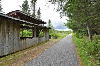 A trail-side rest stop on the P'tit Train du Nord highlights the services available to cyclists, including places to rest, refuel, and enjoy extended multi-day touring adventures.
