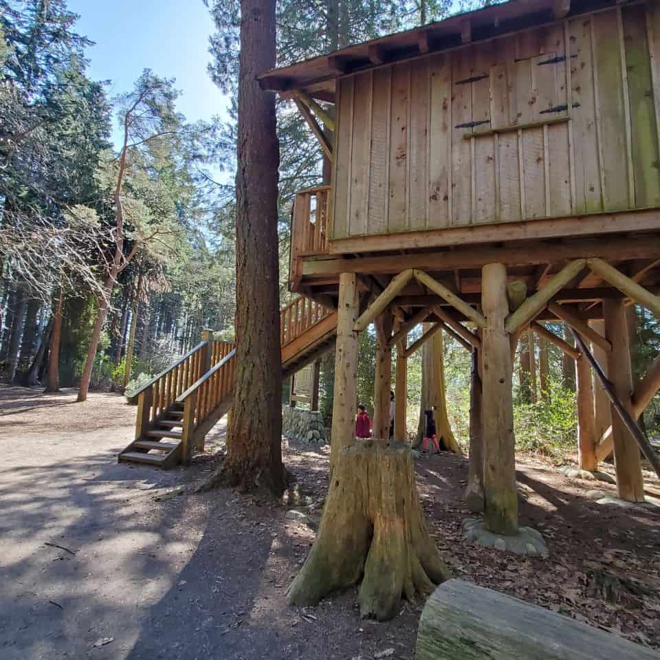 A family passing the base of the treehouse allows us to see the height of the building. A wonderful place for a family outing.