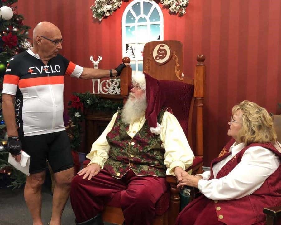 Robert Fletcher, Canadian Adventure Cyclist visits with Santa Claus at the start of his Guinness World Record E-bike Ride from Alaska to Panama.