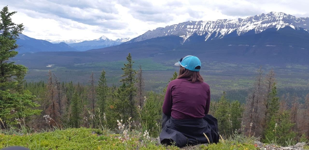 Sitting on the mountain top at the Devona Lookout and enjoying the view of the valley below in Jasper National Park Alberta Canada