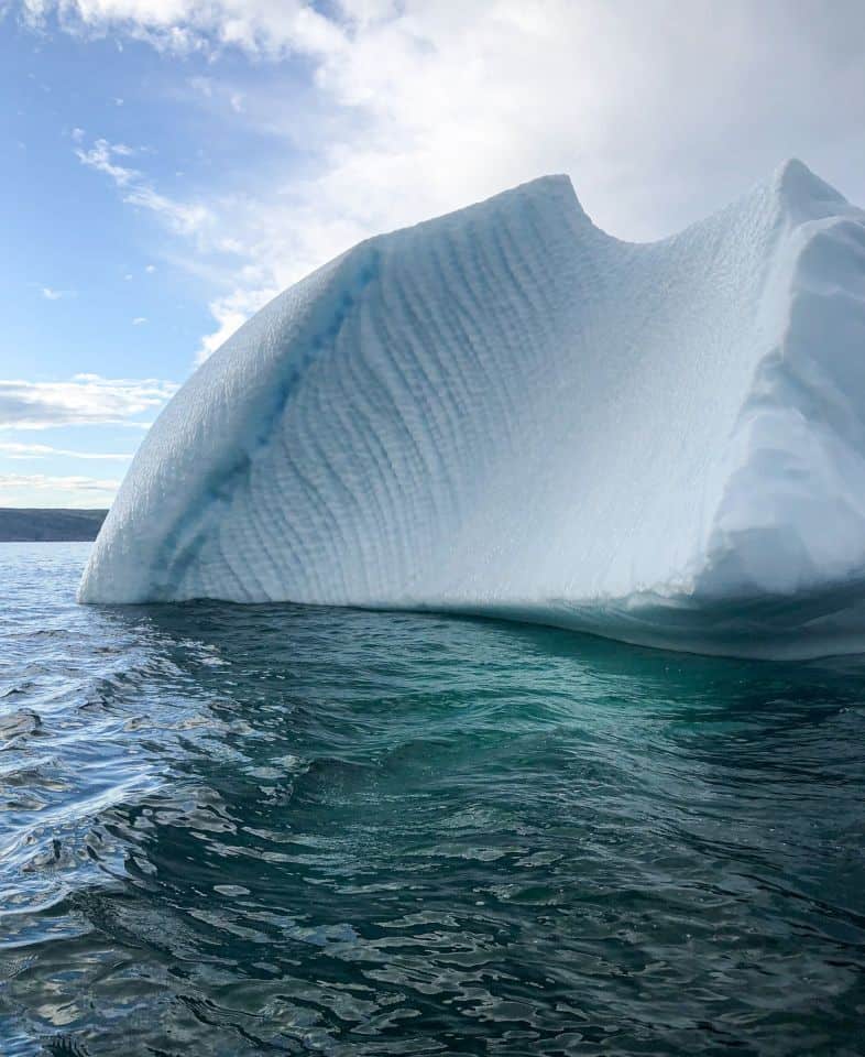 Carved iceberg with slide grounded in Conception Bay Newfoundland and Labrador Canada.