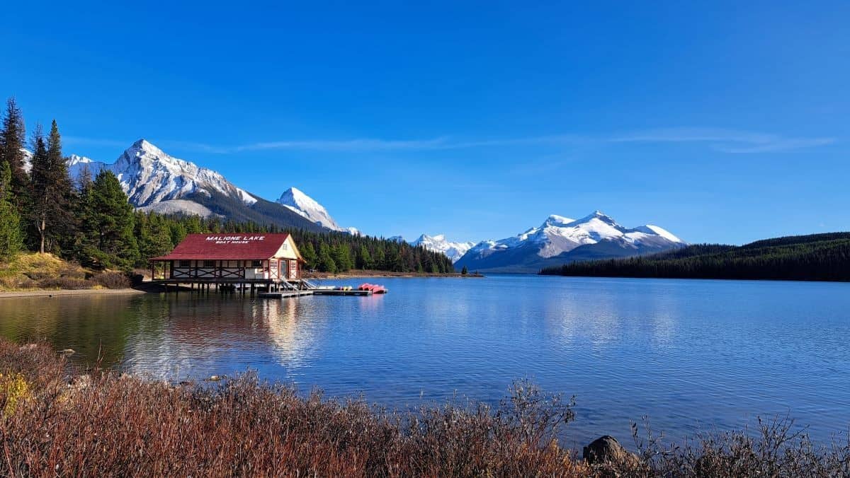 A view looking out onto Maligne Lake in Jasper National Park in the Canadian Rocky Mountains with the famous boathouse in the distance.