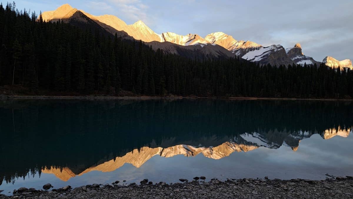 The mountains are perfectly reflected on the mirror-like waters of Maligne Lake