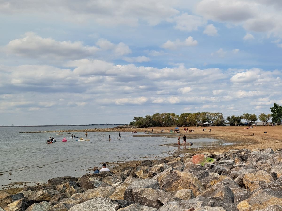Visitors to Kinbrook Island Provincial Park near Brooks Alberta enjoy swimming, watersports and playing on the sandy beach