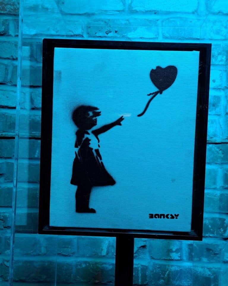 A black and white stencil of the Girl with a Red Balloon on display at Banksyland in Edmonton Alberta.