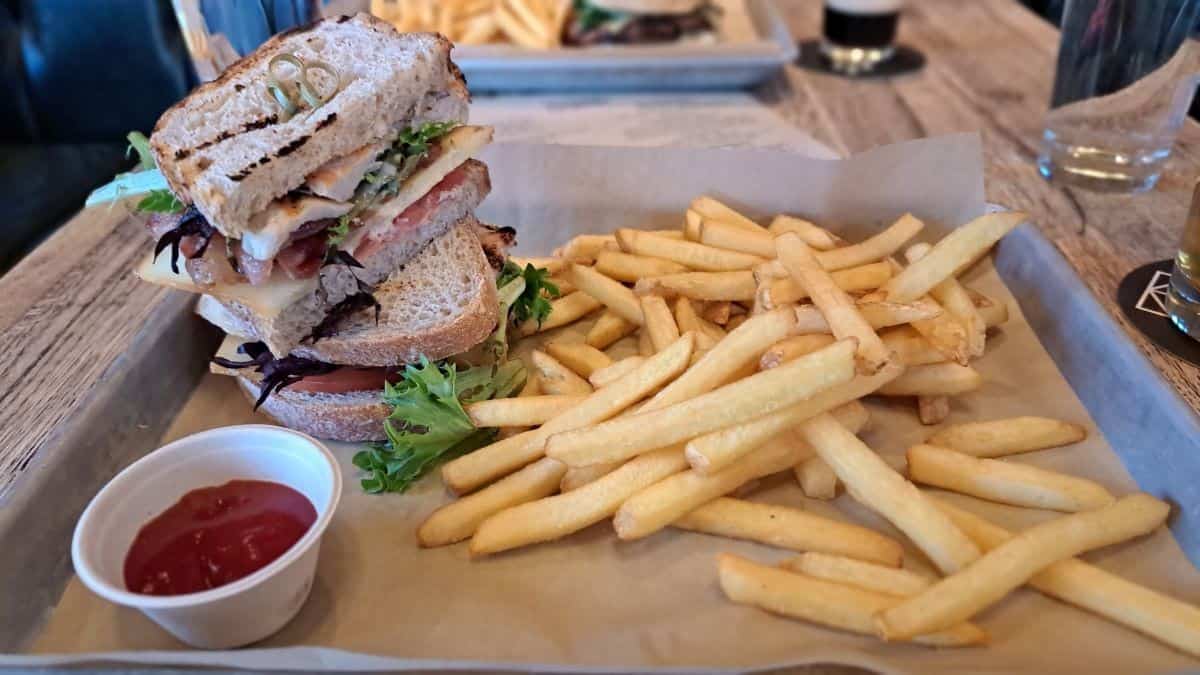A clubhouse sandwich and fries makes a great lunch at Folding Mountain Brewing near Overlander Mountain Lodge Alberta