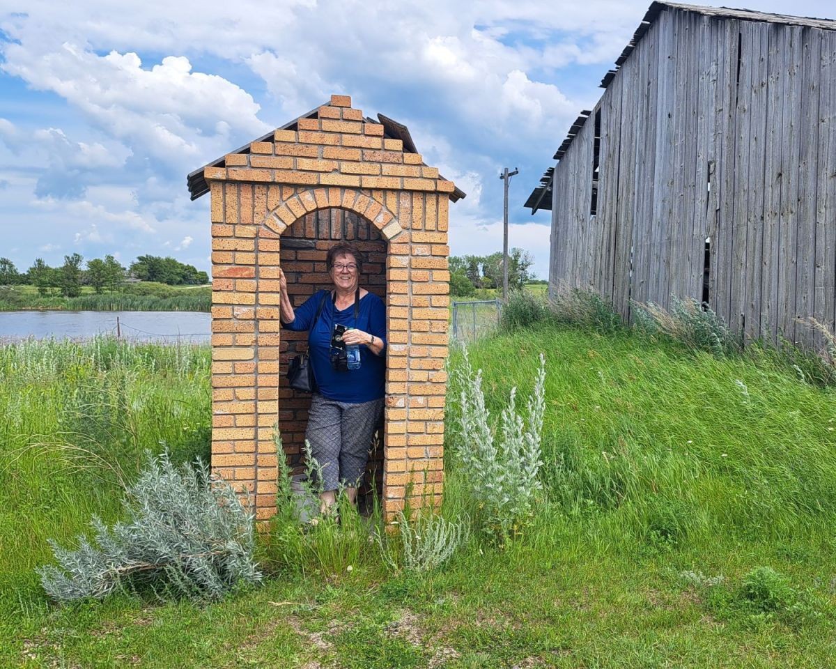 Canada Adventure Seeker Diana Morhsen poses for a photo in an old brick buildling that looks like a guard station at the Claybank Brick Plant National Historic Site near Moose Jaw SK