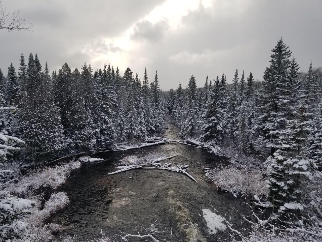 Snow-covered forests, hills, and landscapes are a highlight of skiing, snowshoeing, or snowmobiling the Part linear interprovincial Petit Temis trail in Quebec Canada.