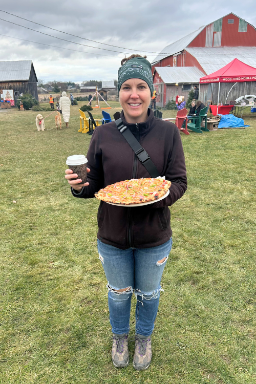 Activities at the Christmas Farm, Anja Cahill with wood fired pizza and hot apple cider, in front of the bonfire.