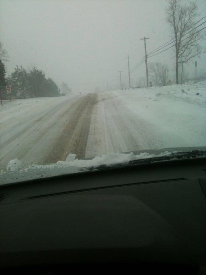 The view through a car windshield of a snow covered country road in Napanee, Ontario.