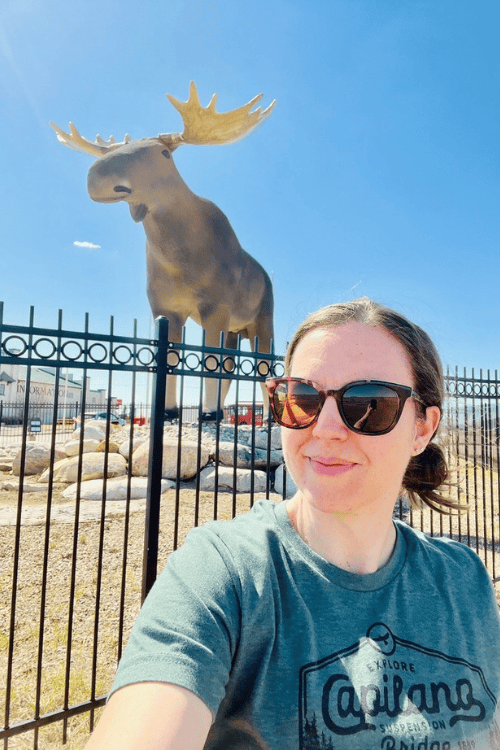 A woman in sunglasses poses with Mac the Moose, Moose Jaw, Saskatchewan.