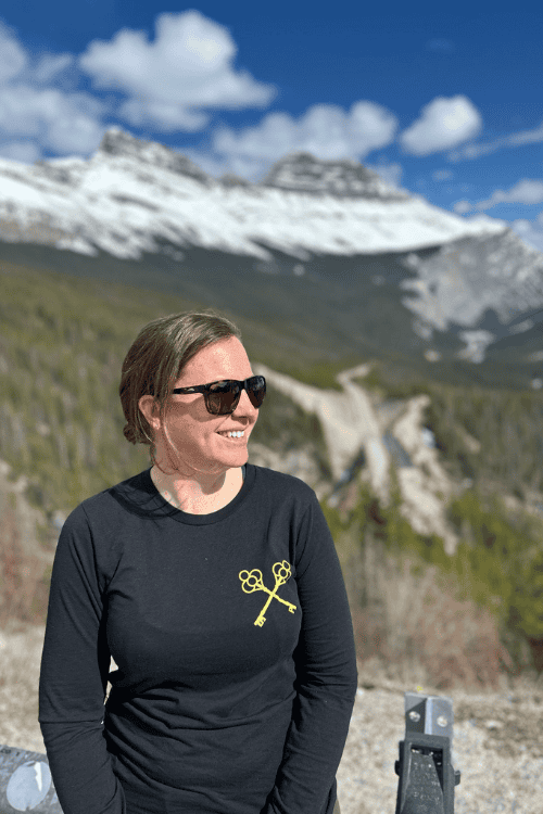 A woman smiles looking out over the Rocky Mountains, Alberta, along the Icefields Parkway
