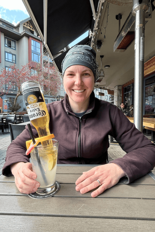 A smiling woman with an interesting cocktail on an outdoor patio in Whistler, BC