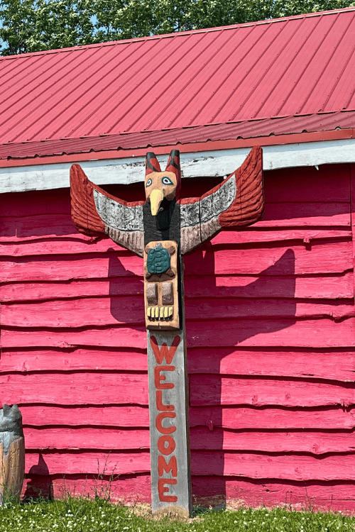 A totem pole of an owl with wing spread and a turtle outside the Ten Mile Trading Post on Manitoulin Island.