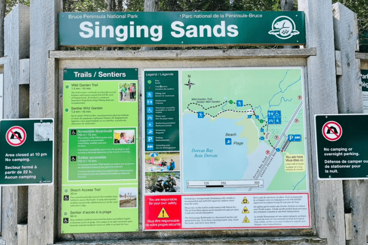 Singing Sands trail head sign at Bruce Peninsula National Park show Trails, maps and cautions.