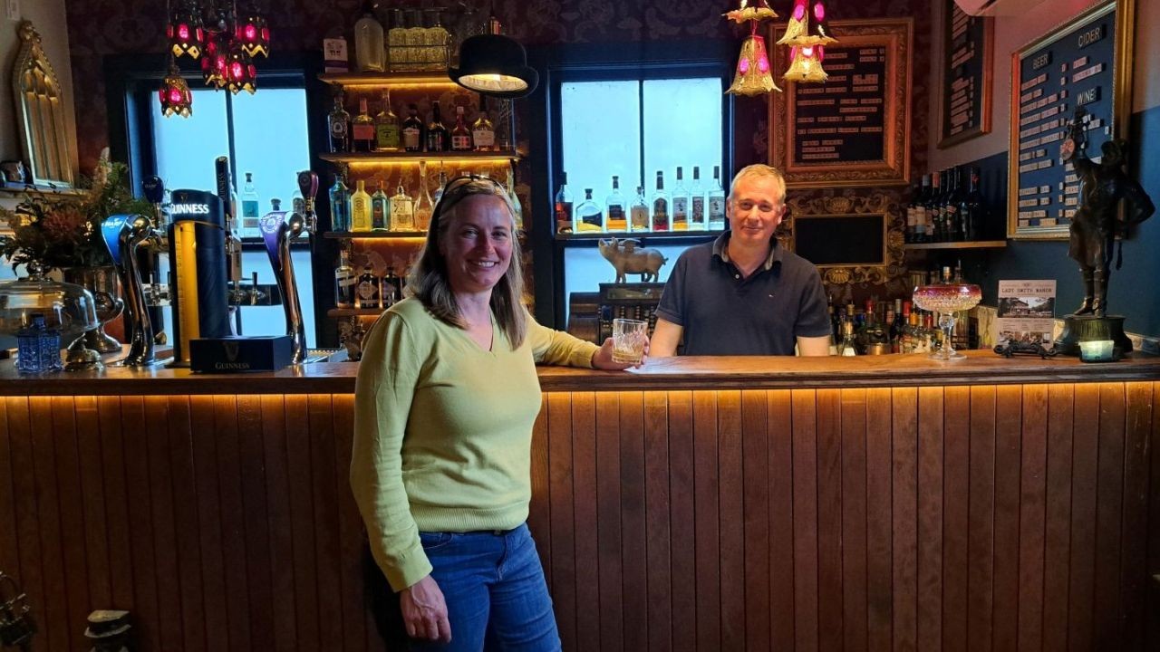 A lady chats with the bar staff in a cozy English pub at the historic Ladysmith Manor in Dorchester NB, Canada