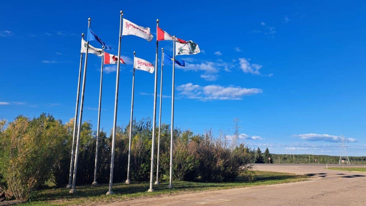 A stand of 8 Canadian, Albertan, Regional Municipality of Wood Buffalo and Syncrude Flags welcome visitors to Gateway Trail
