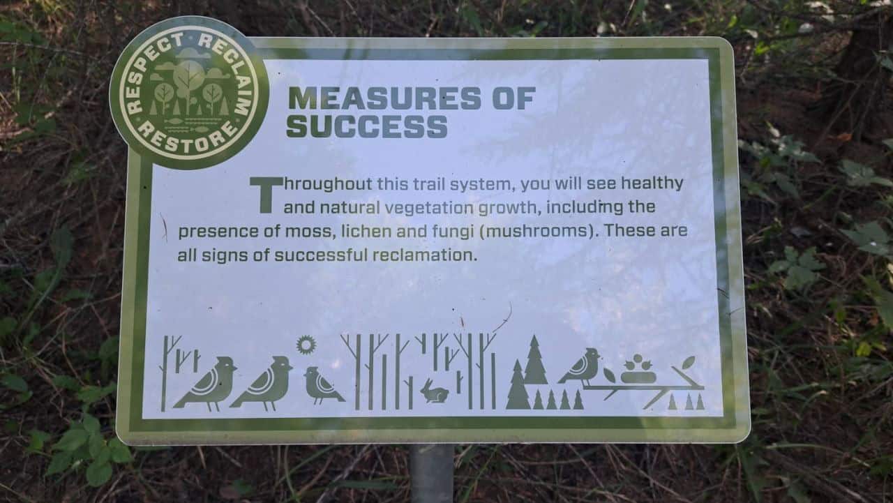 An interpretive trail sign along the Gateway Trail System explains that fungi (mushrooms) are a measure of success in the reclamation process