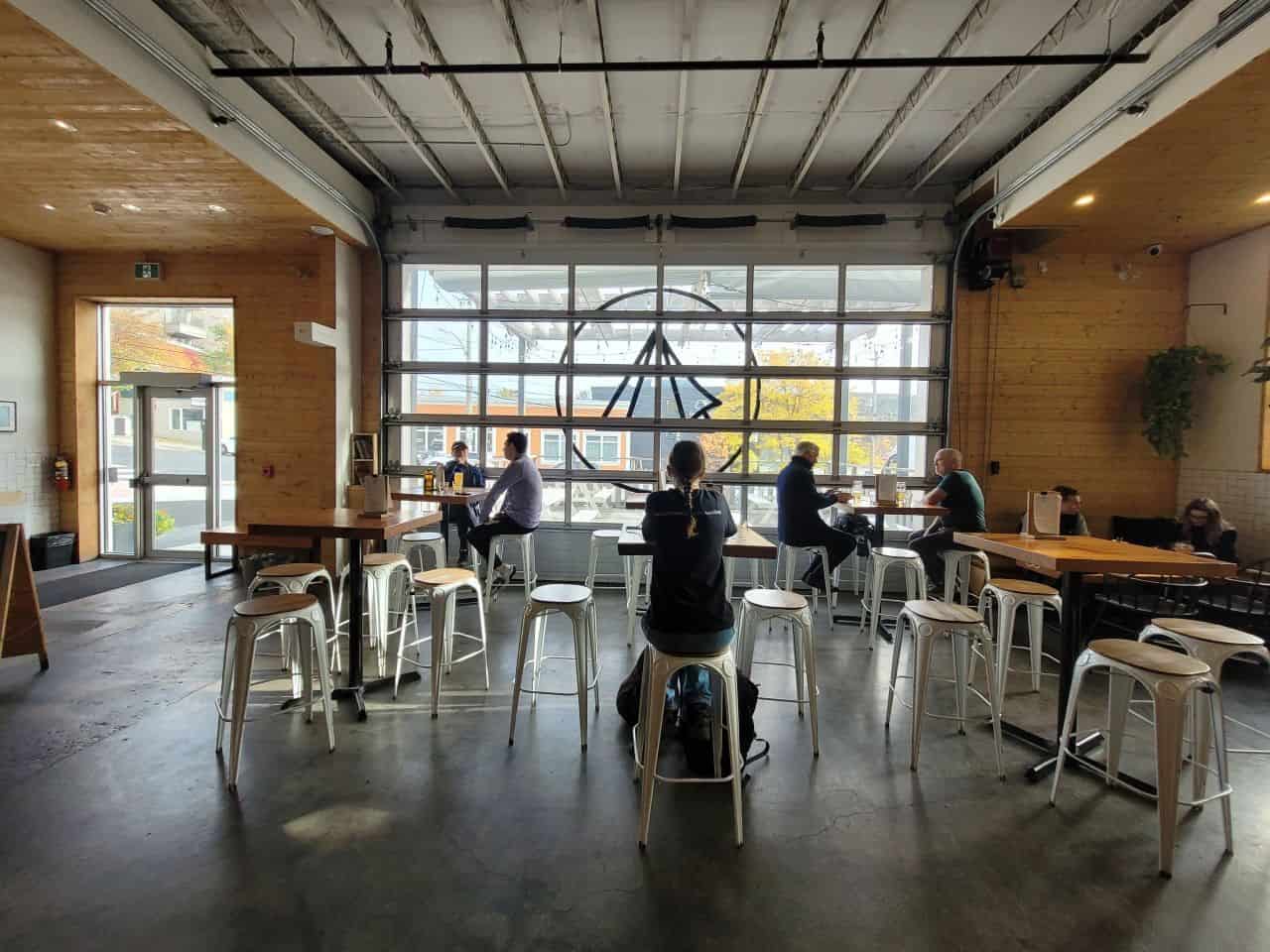 The warm, industrial-chic vibe of Bannerman Brewing Co.’s taproom, featuring exposed brick and communal seating. A perfect space to enjoy innovative craft beers in downtown St. John’s.