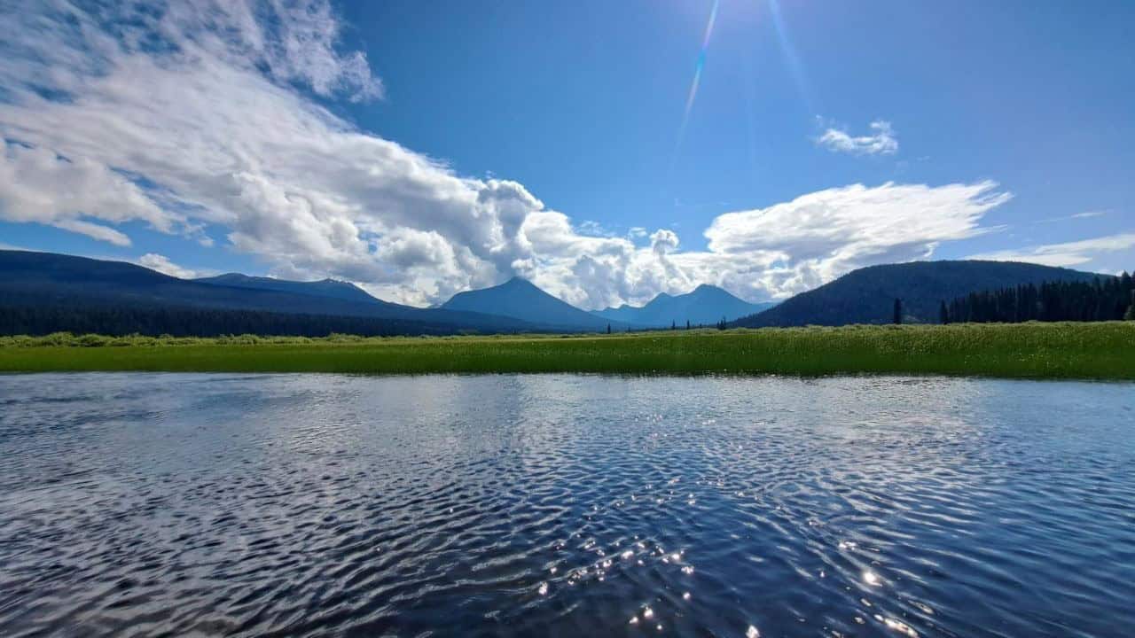 Sunshine and blueskies over the calm waters on the Bowron Lakes Highlands in BC