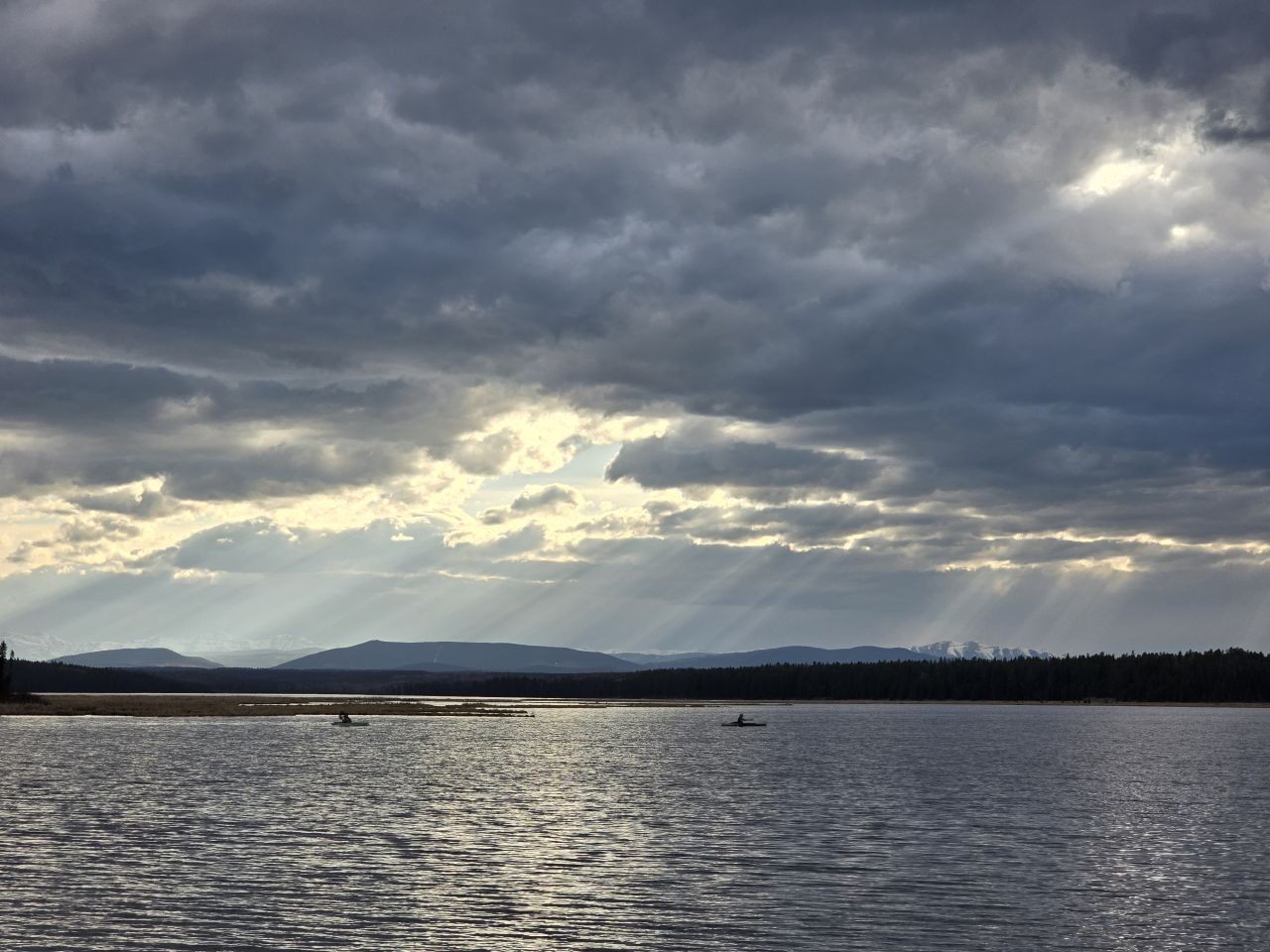Kayaking on a calm lake in Clearwater County Alberta during early spring travel season