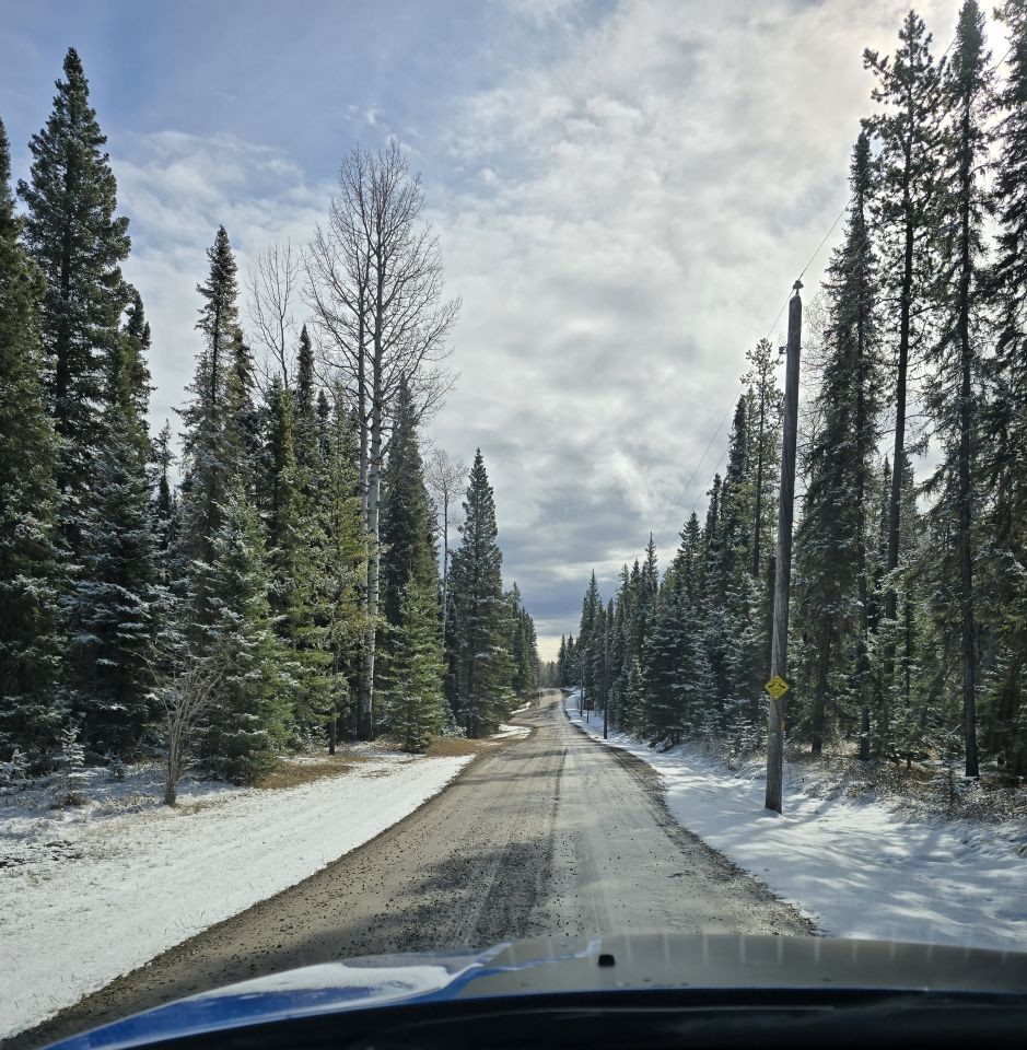 Driving through spring snow on a rural road in Clearwater County Alberta foothills