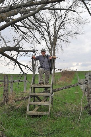 Sean of Come Walk With Us standing atop a wooden stile along the Bruce Trail in Ontario Canada during a day hike, illustrating how short walks and scenic viewpoints allow visitors to experience the Niagara Escarpment.