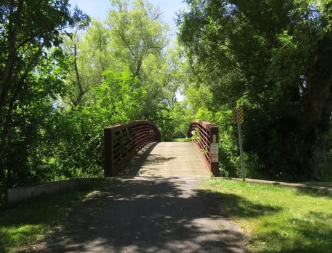 Shaded footpath and small bridge along the Niagara River Recreational Trail in Ontario, Canada, featuring peaceful forested surroundings, quiet walking sections, and a relaxing contrast to busier areas near Niagara Falls.