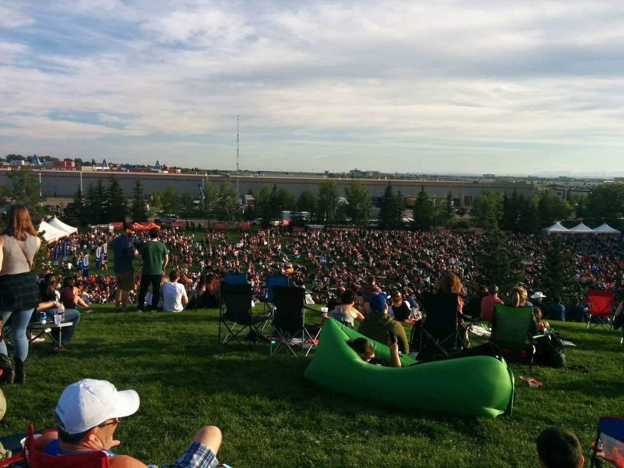 people sitting on hillside watching outdoor summer concert in Western Canada
