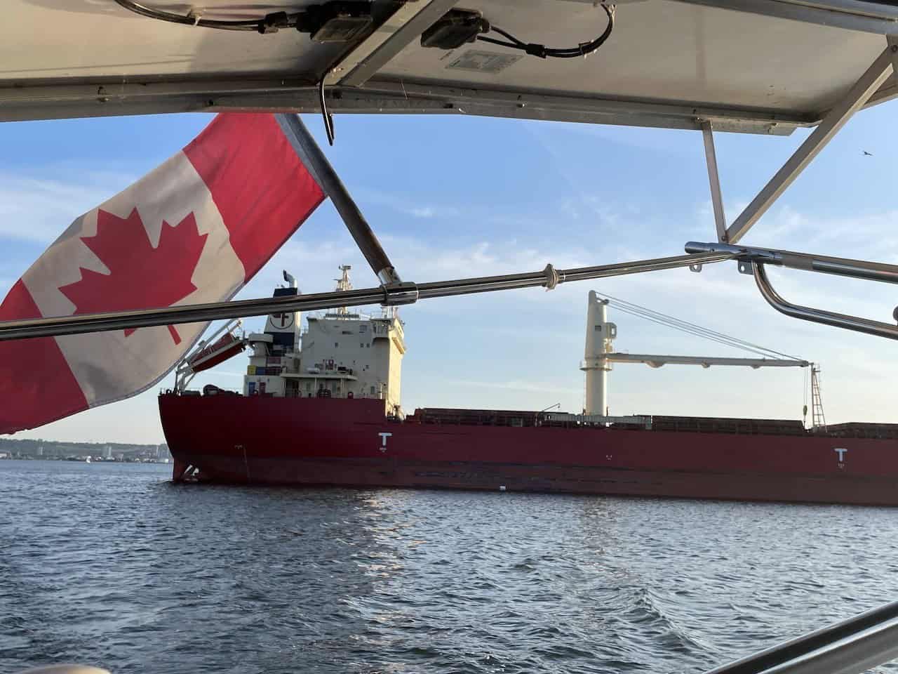 Hamilton Harbour Canada Flag on Sailboat - The Canada flag was prominently displayed on the back of the sailboat. The Canada flag is the flag of the country under which the sailboat is registered.