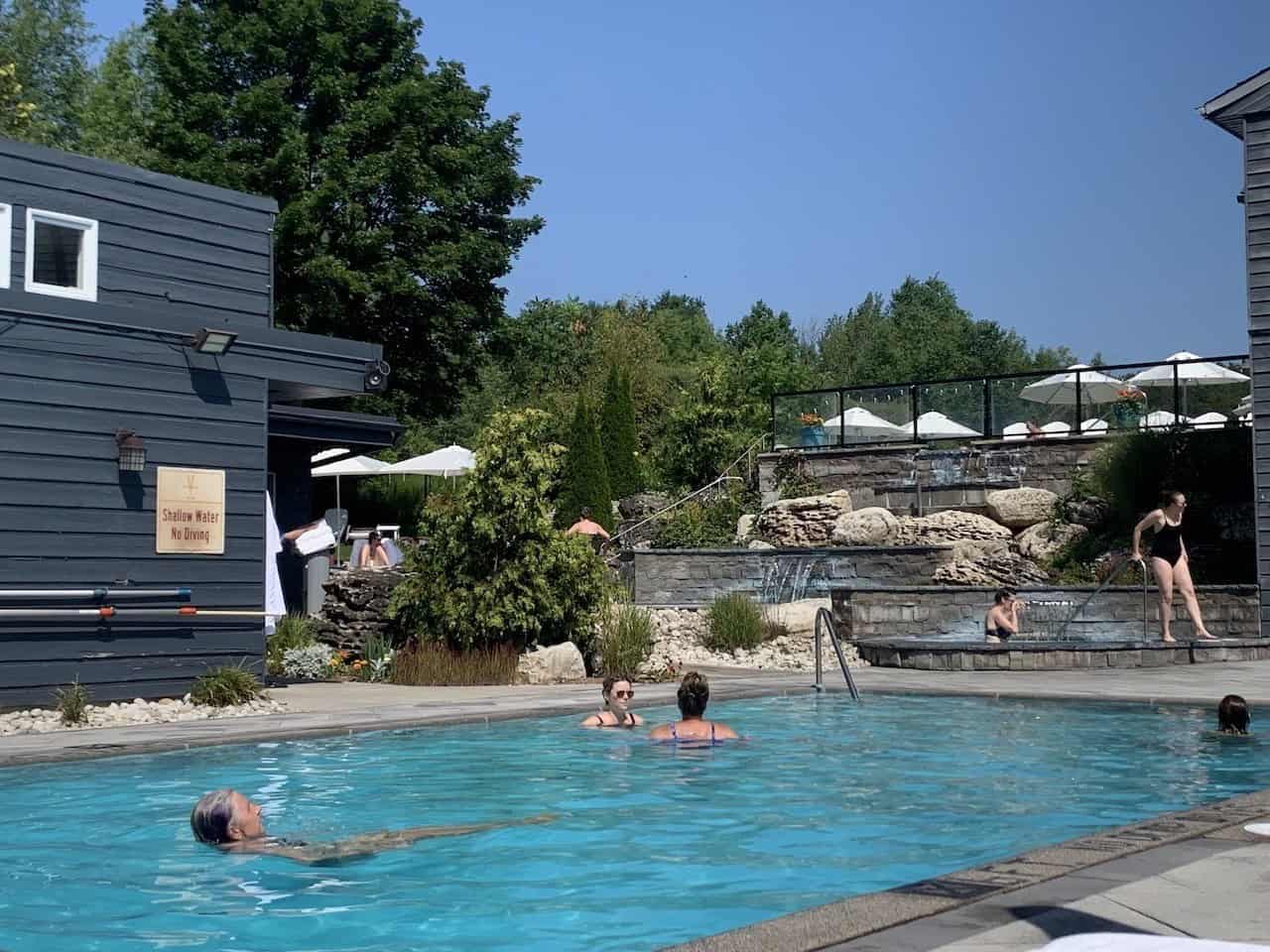 Outdoor Heated Pool at Millcroft Inn and Spa Alton Ontario Canada - The outdoor heated pool at Millcroft Inn and Spa is open all year around for guests to enjoy. The lounge chairs and umbrellas along the sides of the pool are a popular sitting spot for guests.