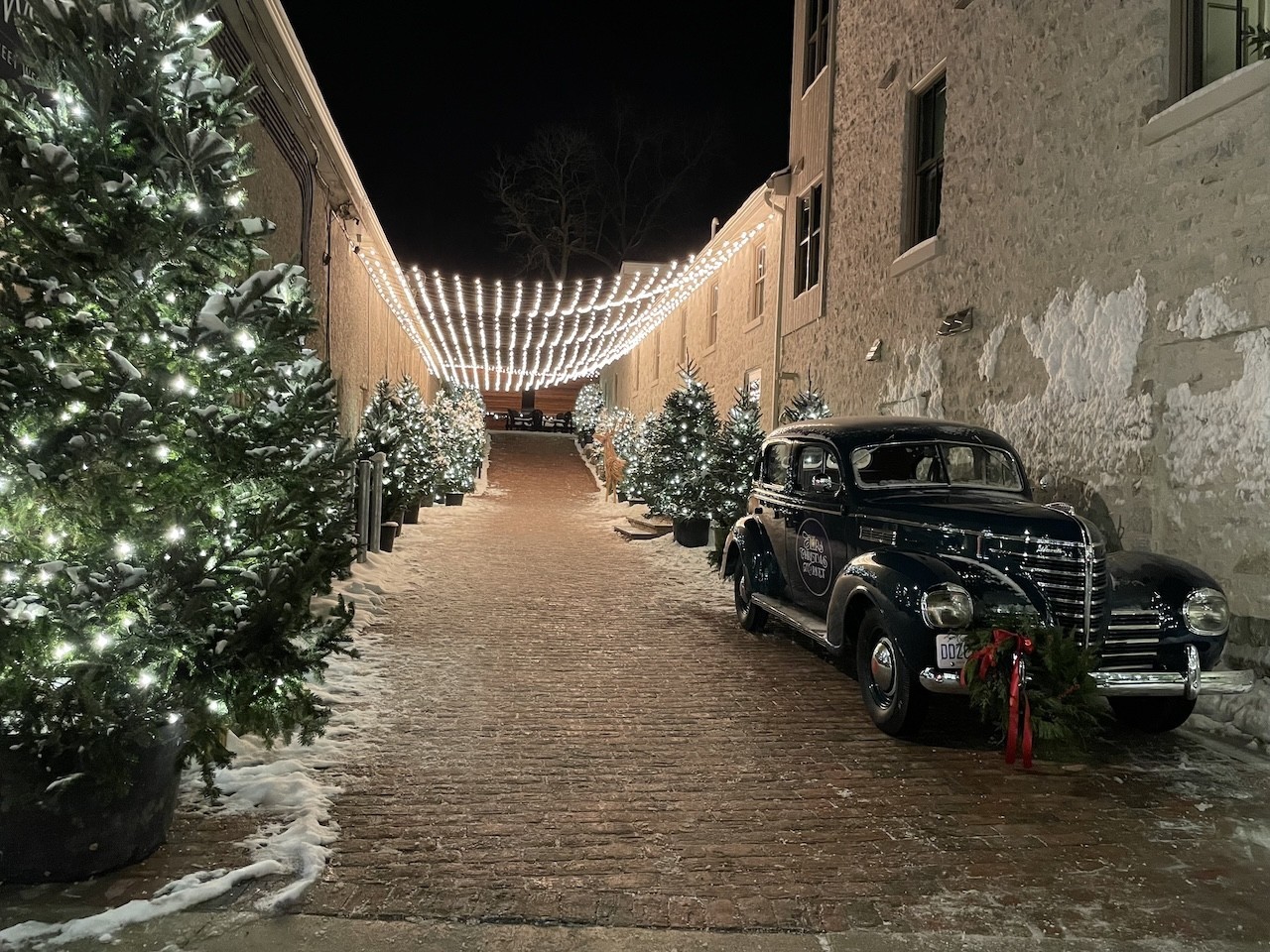 Winter Walkway Elora Ontario Canada - This festive walkway in Elora featured an antique car and a glowing light canopy draped between the buildings. 