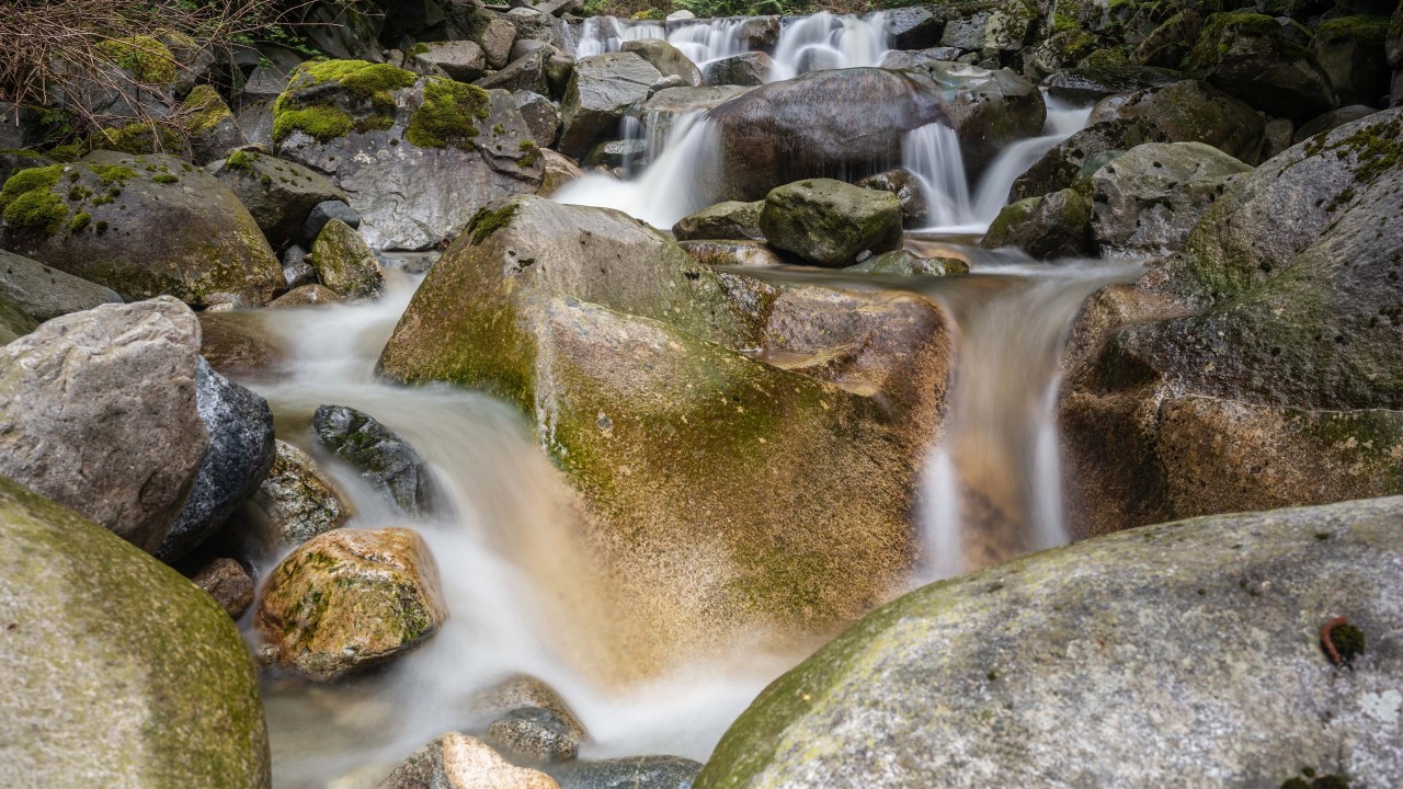 rocks-and-whitewater - Crystal clear water rushes over the rocky river bed from high above in the Rocky Mountains in British Columbia Canada.