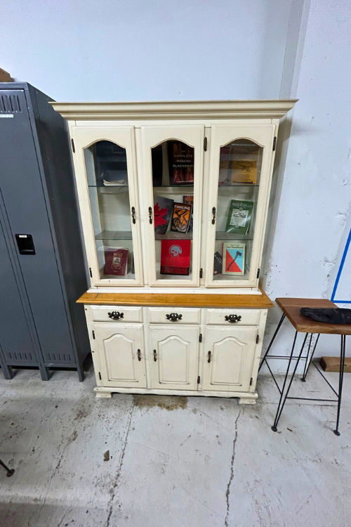 History-of-axe-forging - A dining hutch makes a great storage display of books and paraphernalia describing the art of blacksmithing and information on axes.
