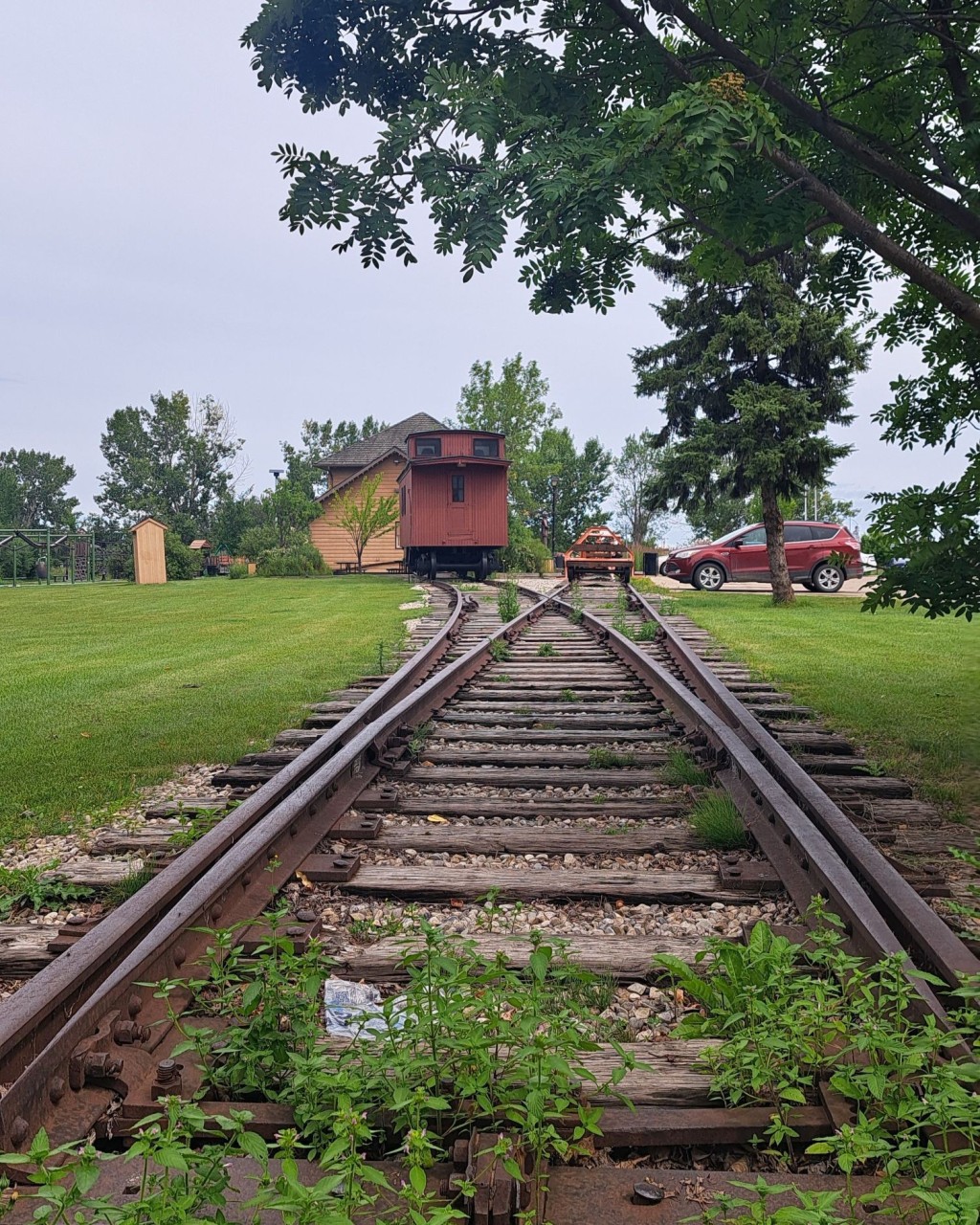 Historic Railway Line Leading to Caboose and Visitor Centre - From the park entrance, the old rail line leads to a caboose and the Visitor Centre, styled like a historic station. A charming walk blending history and nature.

