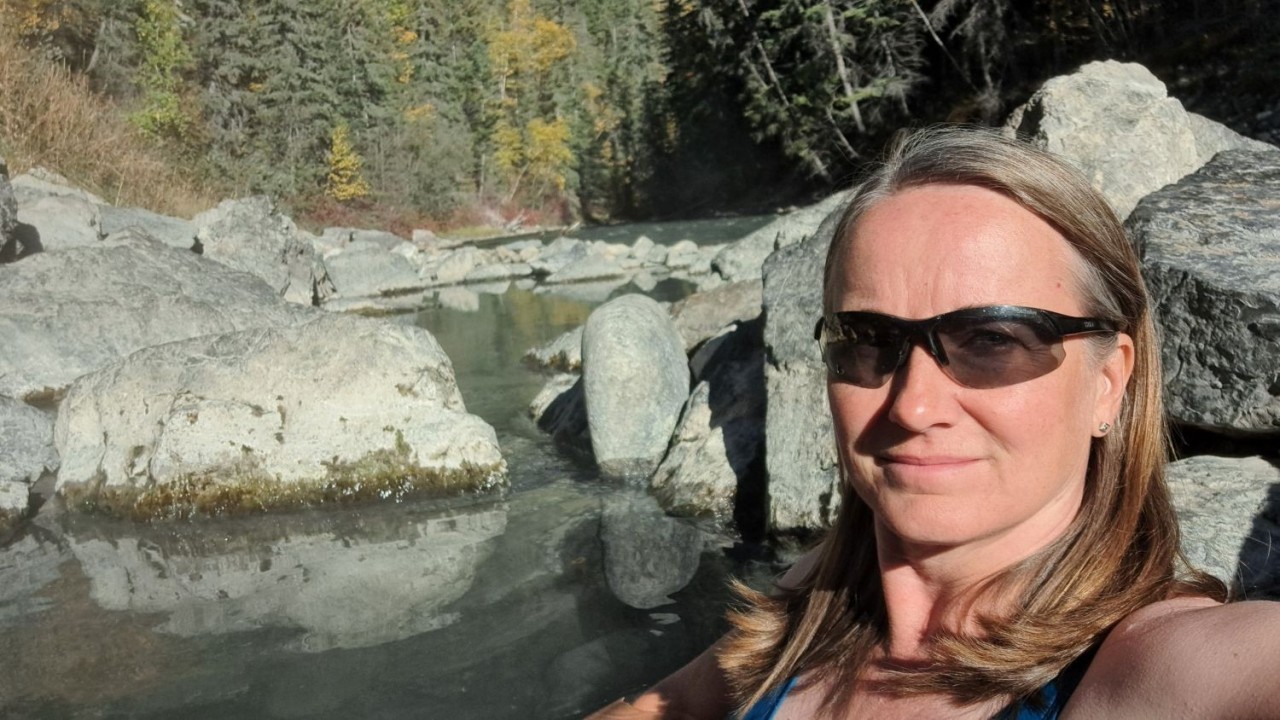 Relaxing in Lussier Hot Springs Mineral Pools – East Kootenays Hot Springs - I settle into the warm upper pool with steam drifting around me. Natural rock walls and fresh mountain air create a relaxing backcountry spa moment.