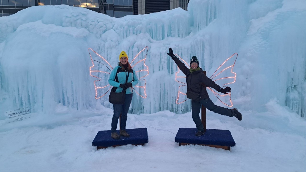 Friends at Fairy Wings in Edmonton Ice Castles, Winter Fun Alberta - Friends pose beneath glowing fairy wings, one of the most popular photo spots inside the Edmonton Ice Castles. Interactive installations encourage creativity while celebrating fun, friendship, and winter adventure in Alberta’s capital city.
