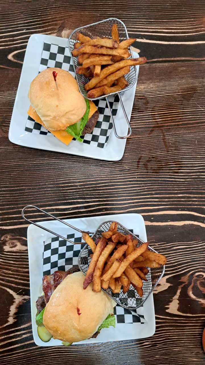 DW Smash Burgers at Dark Woods Brewing - The DW Smash Burger stacks up Alberta beef patties with melty cheese, their house-made sauce, and that sweet Morning Wood onion jam that takes it over the top. Crispy edges, messy in the best way. Add the fries. Trust us.