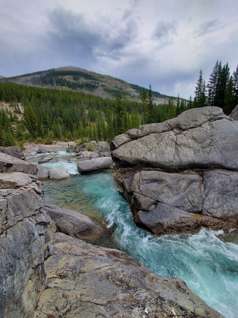 Turquoise Waters at Hummingbird Falls - Crystal-clear blue water rushes through smooth canyon rock near Hummingbird Falls in Alberta’s backcountry