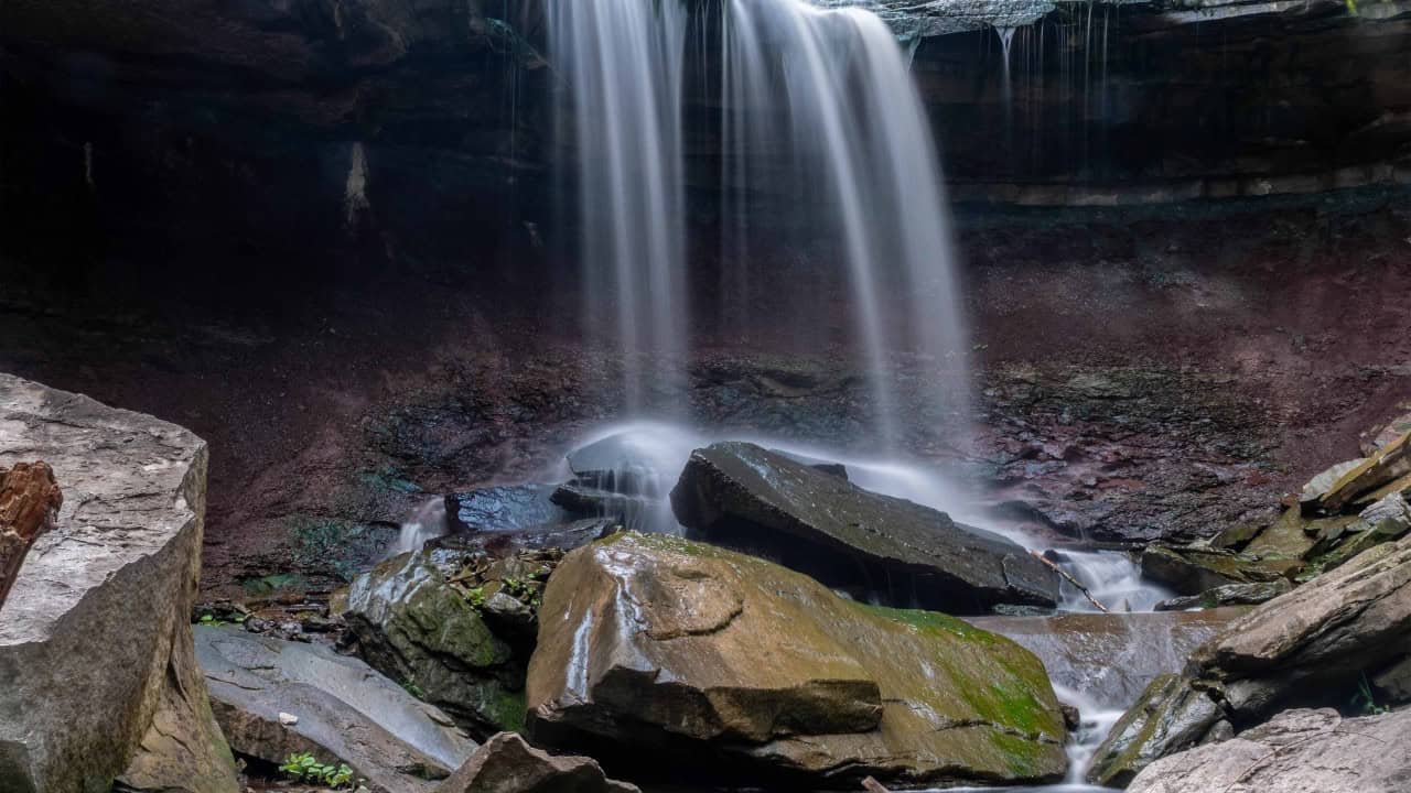 Lower Devil’s Punchbowl Falls - While its massive sibling upstairs gets all the viral fame, the Lower Falls offers a much more intimate, secluded forest atmosphere. Tucked away down in the lower valley, it feels like stepping into a hidden ravine world away from the main lookout crowds. This is a beautiful 5.5-meter (18-foot) classical cascade where Stoney Creek takes its second major plunge down the Niagara Escarpment. Unlike the sheer, vertical drop of the Upper Falls, the water here rushes over a rugged slope of stepped limestone and fractured boulders, pooling beautifully at the base before continuing its journey toward the CPKC railway line.